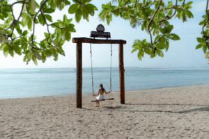 A relaxing day out in Nusa Dua pictured with calm turquoise ocean waters gently lapping a white sand beach lined with sun loungers